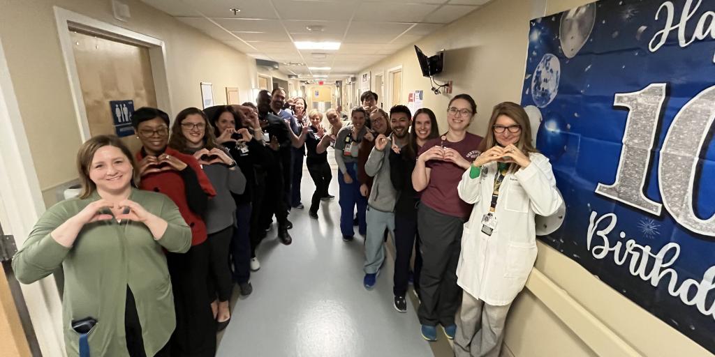 Group of people displaying heart signs.
