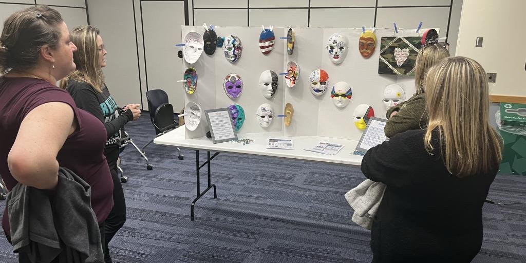 (Left) Dr. Steinzor explains the purpose behind the Empowerment Masks to (left to right) Abigail Carter, Heather Herlin, and Joanne Barrett.