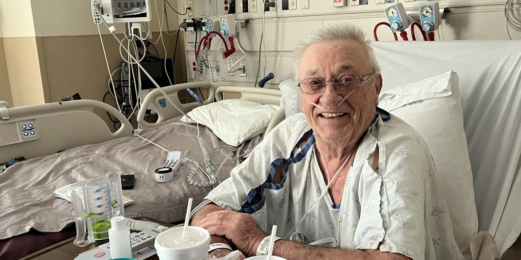 A Veteran in a hospital gown smiles for a photo days after receiving an interventional pulmonary procedure