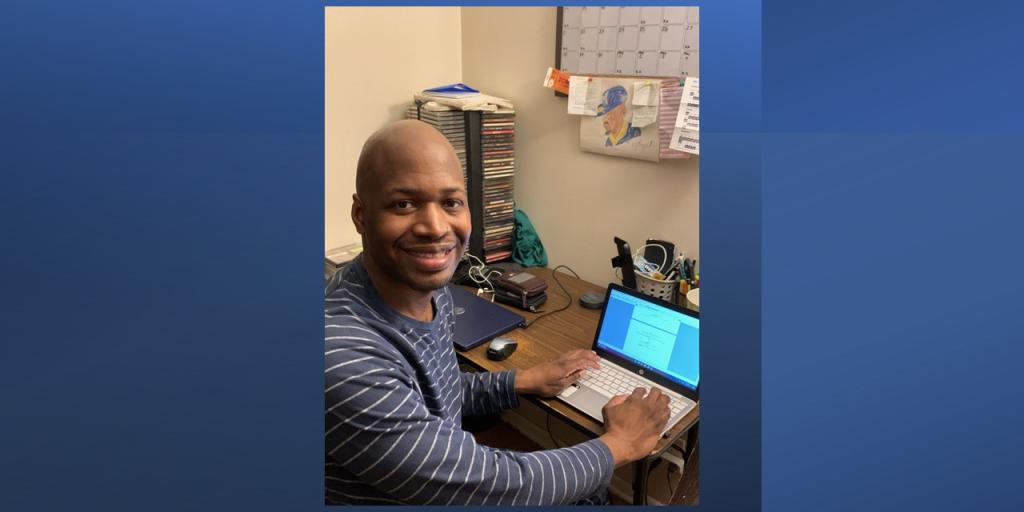 Man sitting at computer looking at camera