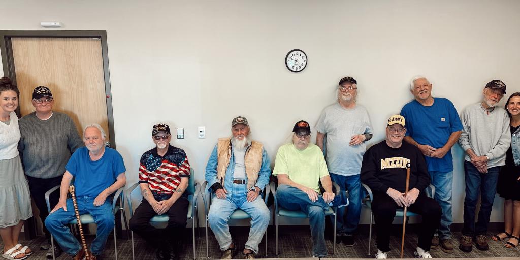 A group of Veterans from Quincy, IL sits and stands