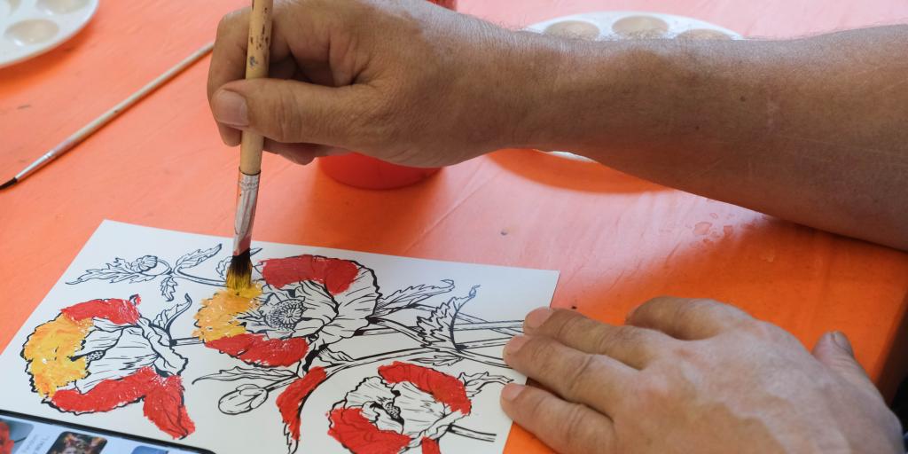 close up of veteran painting a poppy