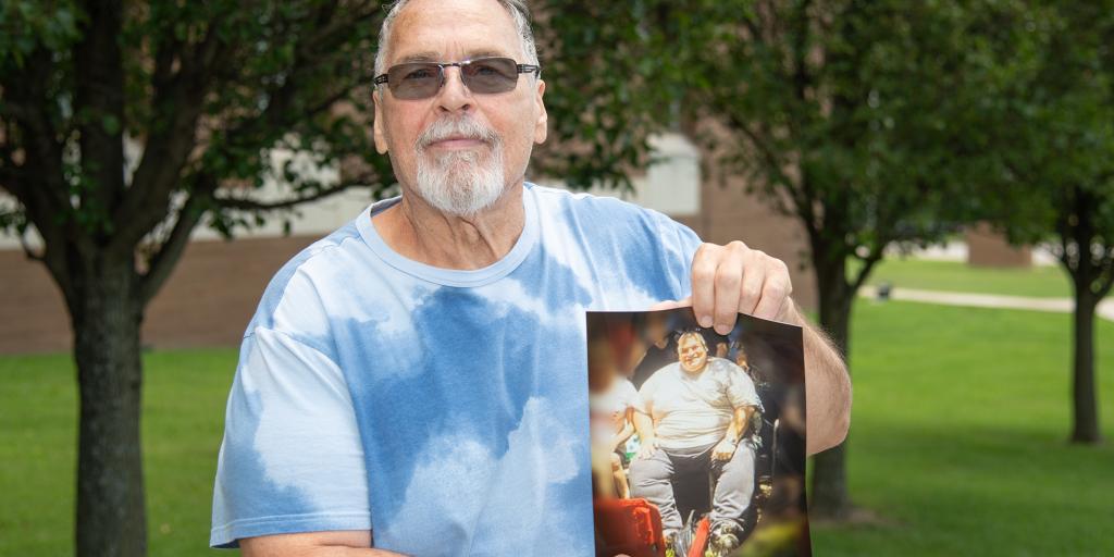 Ronald Kraus shows a photograph of himself before he lost 163 pounds.