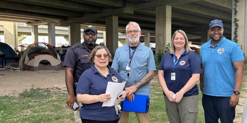VA staff pose for a photo under a bridge.
