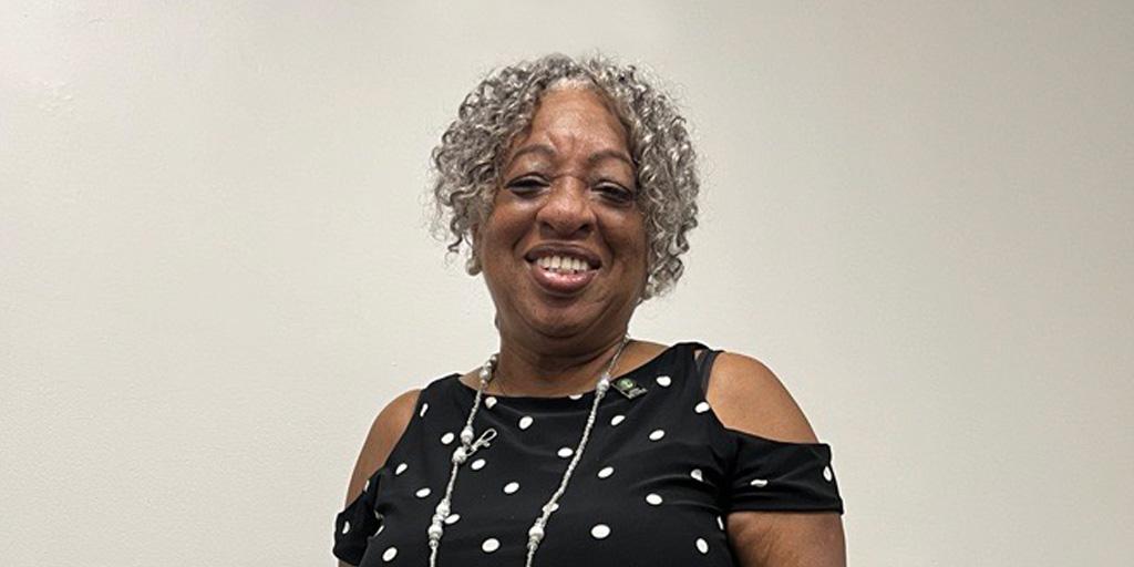 Woman standing and smiling.