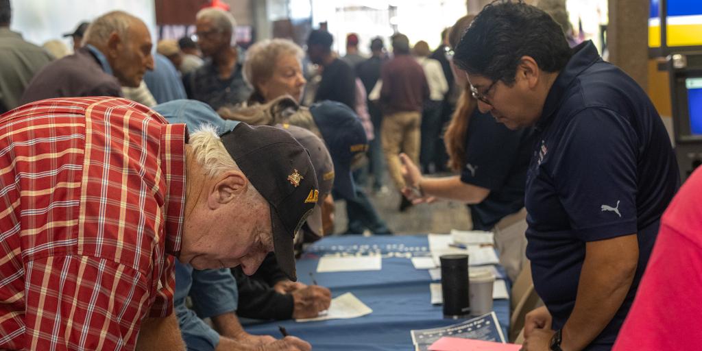 Outreach Coordinator Jesus Molina assists a Veteran at the Jesse Brown and Hines fall resource fair hosted at Governors State University.