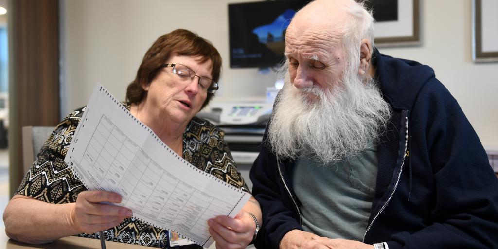 Volunteer Sharon West aids John Hilpl, a U.S. Navy Veteran from Dexter, NY cast his absentee ballot