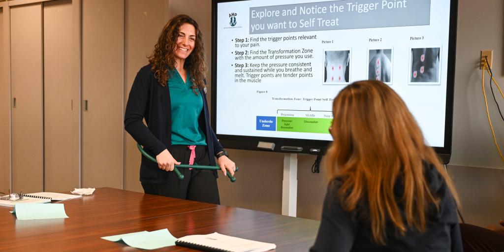 Dr. Amanda Brooks, AMP program manager and Doctor of Physical Therapy, shows AMP participants to use a Massage Trigger Point Cane. 