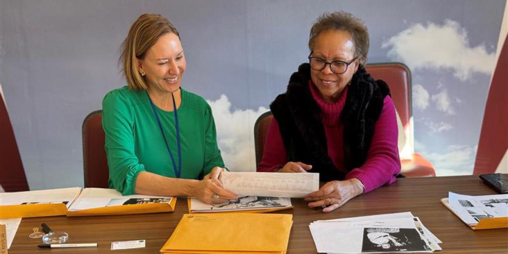 Dr. Maureen Thompson, CAVHCS Historian (left), and Denise Dixon, daughter of Dr. Mildred Dixon, former CAVHCS podiatrist, sort through photos in 2024.