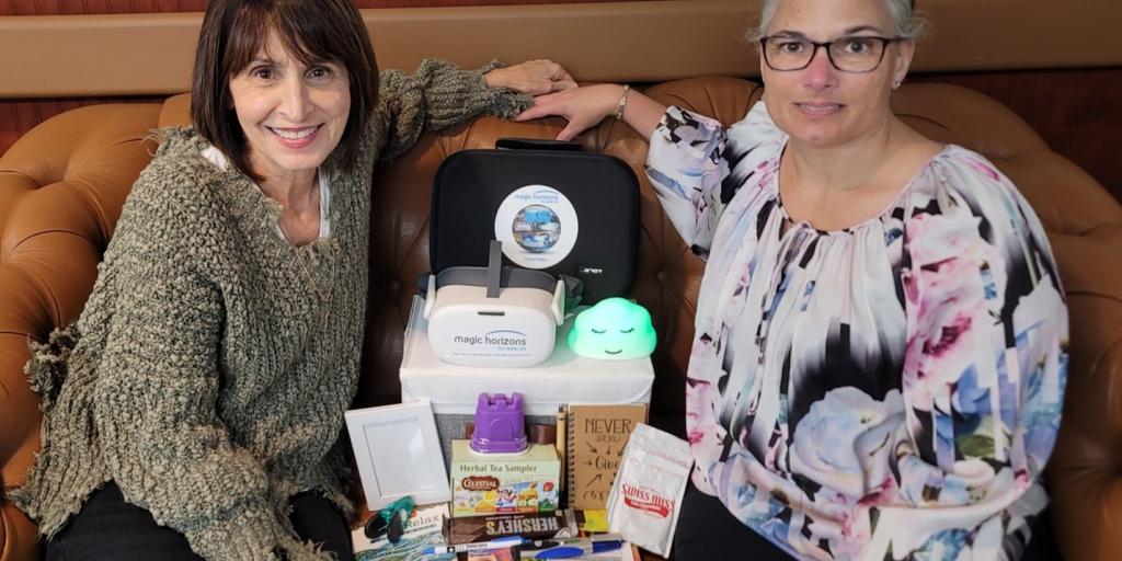 Dawn Mucha-Johnson and Adelina Sowell show the VR items Veterans receive when participating in the 360 degrees of Hope project. 