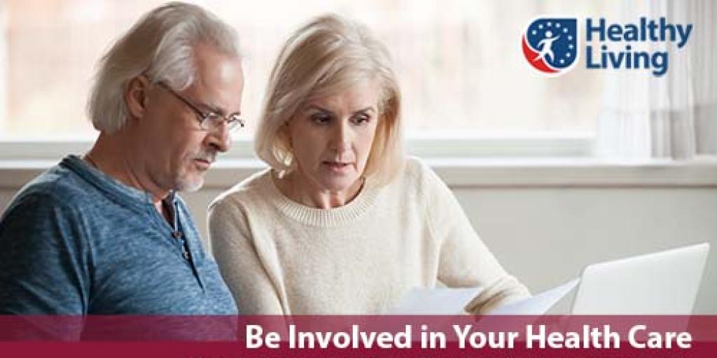 an elderly man and woman reviewing documents in front of a laptop computer.