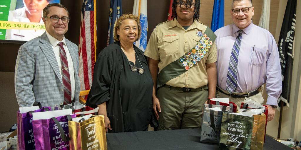 group picture with boy scout, medical center director, boy scout's mom and chaplain