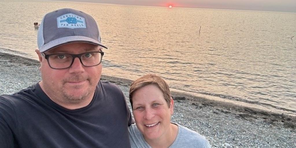 Man and woman standing on the beach smiling