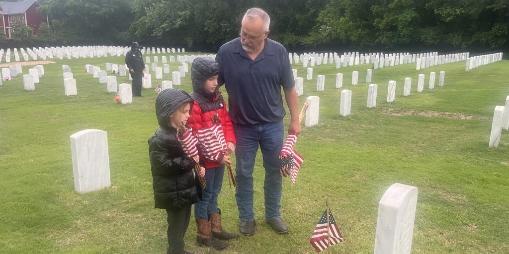 Grandfather standing with children at Fayetteville National Ceremony.