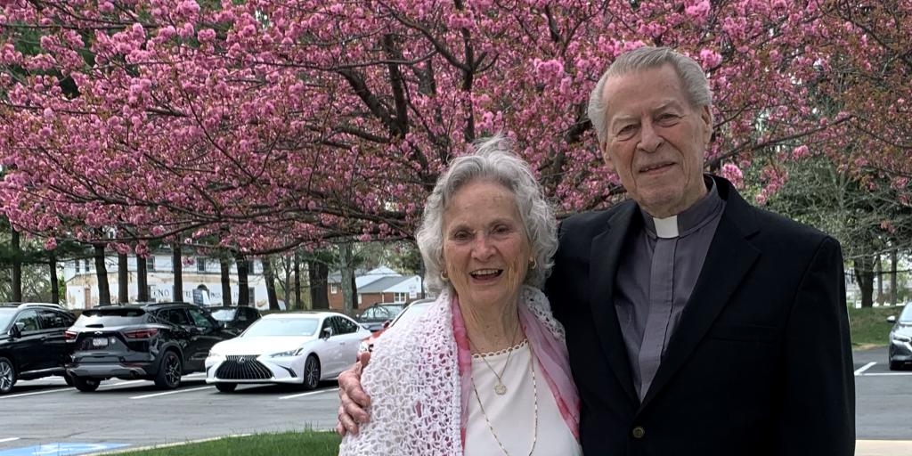 A Veteran couple pauses as they walk down the sidewalk.