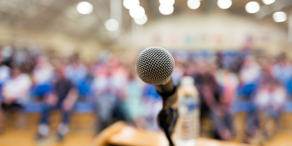 microphone in front of an audience. 