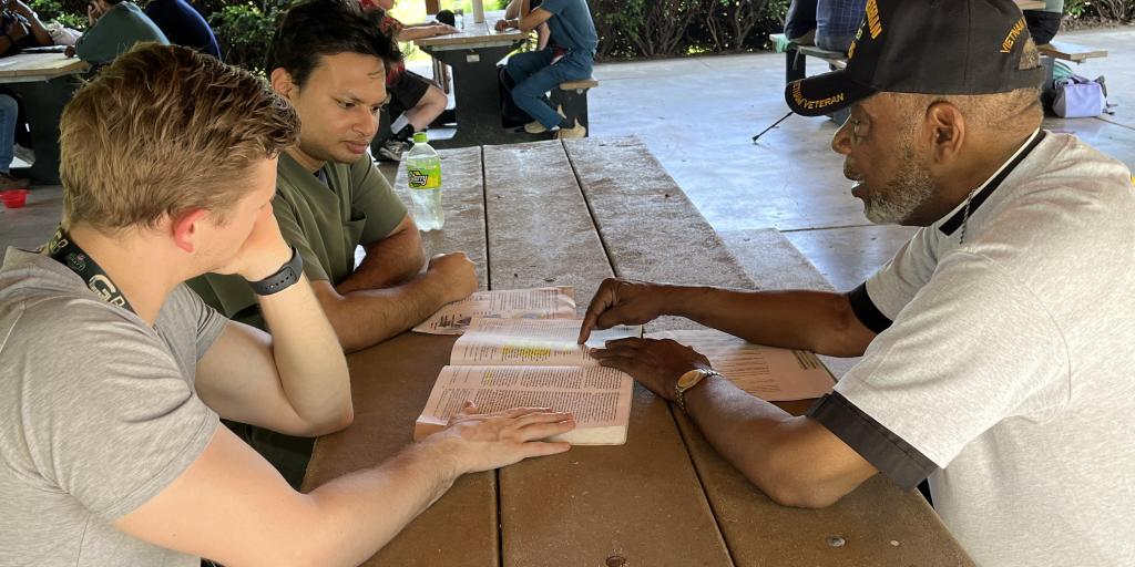 Two students listen to a Veteran describe his combat experience.
