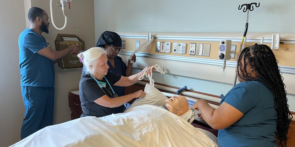 employees conducting simulation with a mock patient
