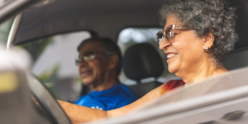 woman driving car with man in passenger seat.