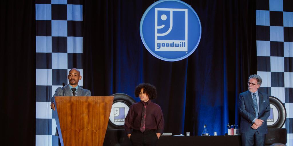Marcus and his son on stage accepting award.