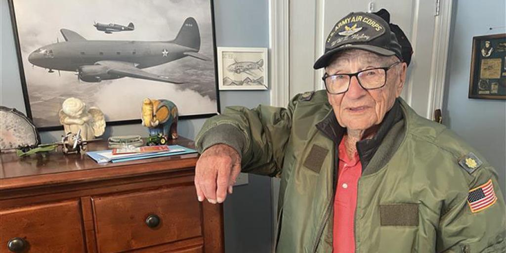 World War II Veteran Mr. Joseph Balogh poses next to snapshot of a C-46 Commando at his Louisburg, North Carolina home.