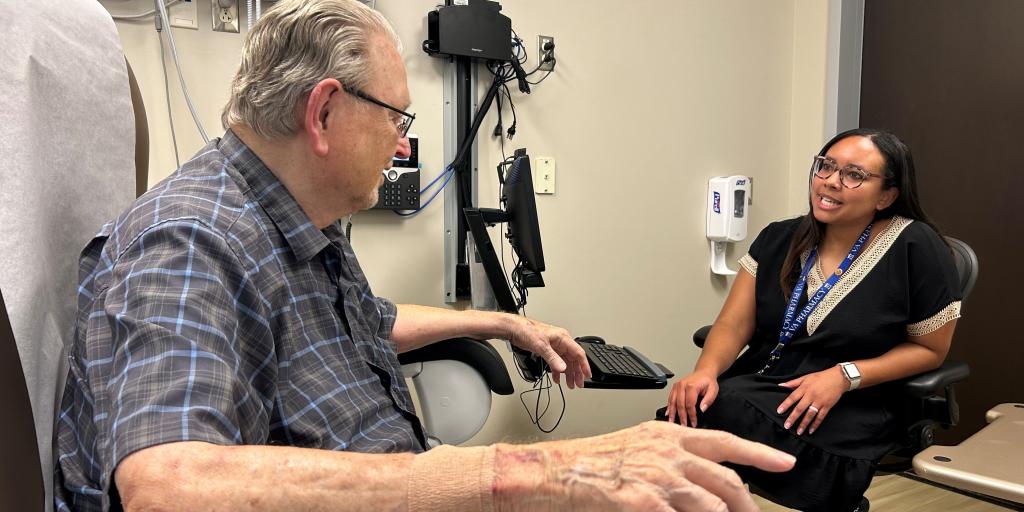 Mallory Eley, Pharm.D., meets with a patient to give counseling regarding his medications and answer any questions he may have.