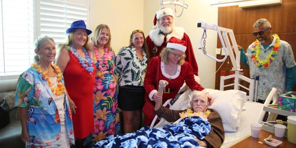Air Force Veteran Edward Cony shares a smile with Santa and his elves during the Santa Salutes visit.