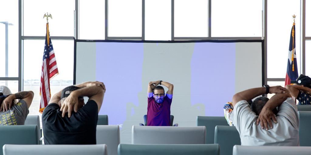Whole Health staff stretching with Veterans during a chair yoga presentation during the Whole Health Summit at Corpus Christi West Point VA Clinic.