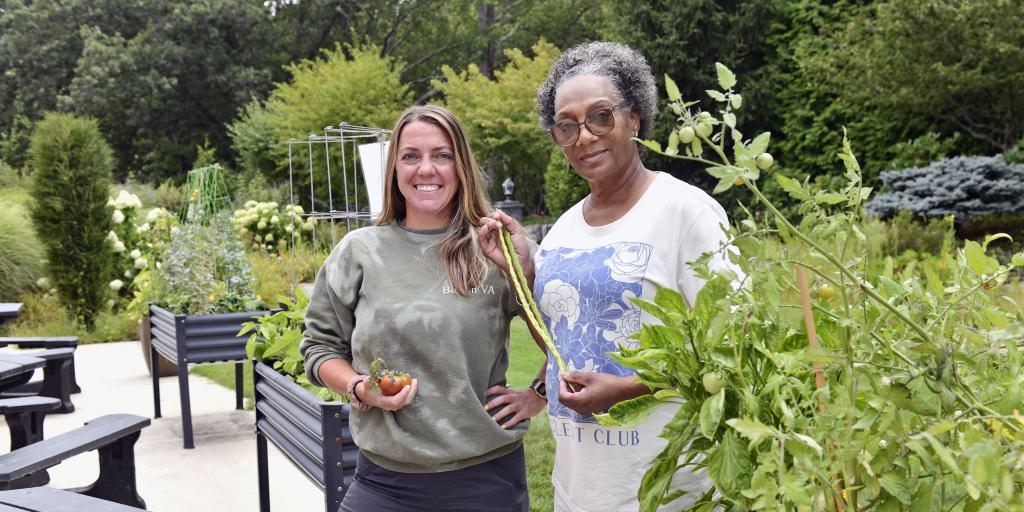 Alisha Long, RN, left, and Kathy Johnson, MSA, with vegetables on the Fisher House patio at the West Roxbury VA campus Aug. 21, 2025.