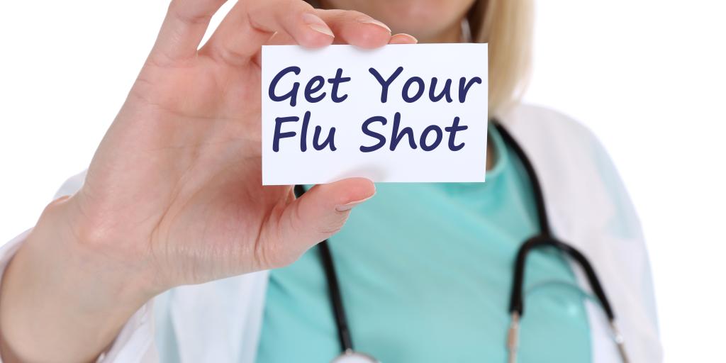 Female provider holding a "get your flu shot" message