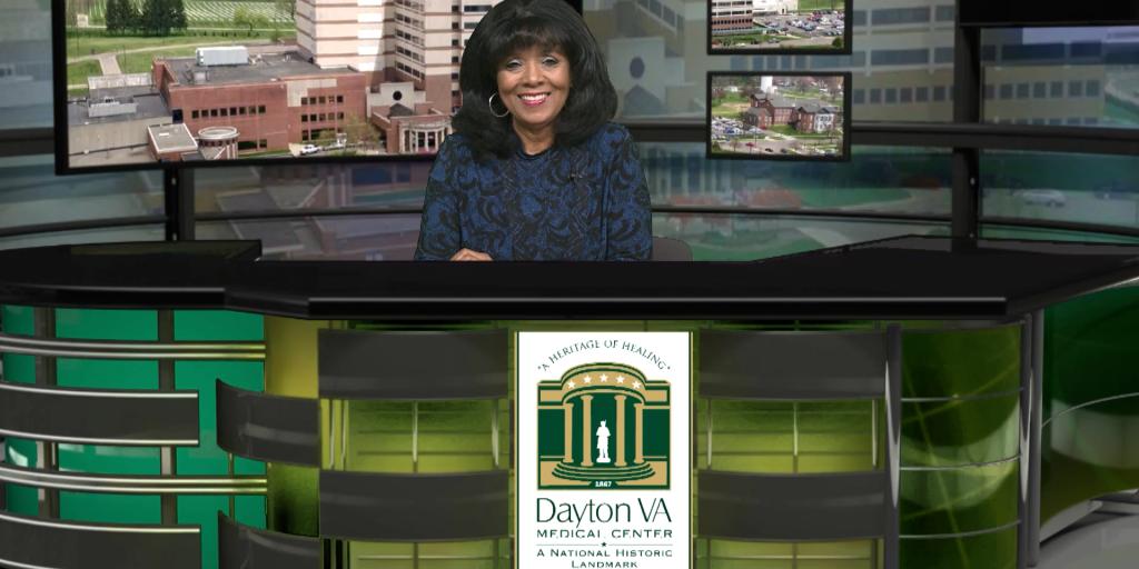 Public Affairs Officer Rhonda Moore sitting at the Good News Report desk.