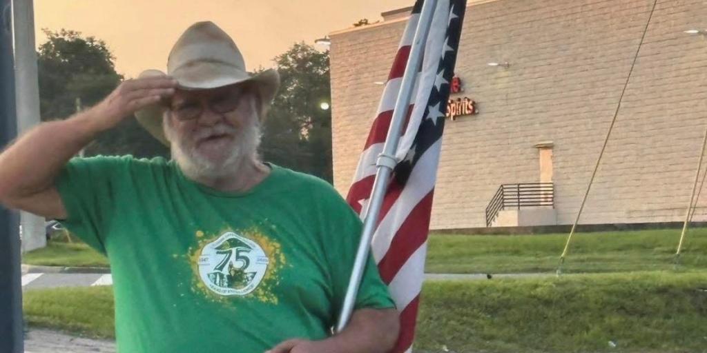 U.S. Army Veteran Terry Hancock, known as the “Lake City Flag Waiver,” salutes from his usual corner, proudly holding his American flag.