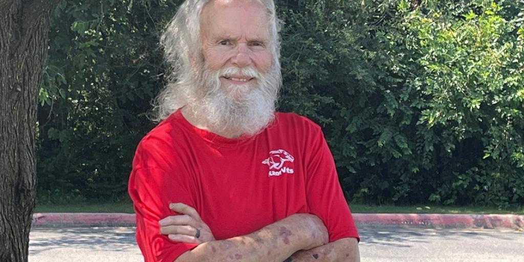 veteran standing by a tree outside smiling