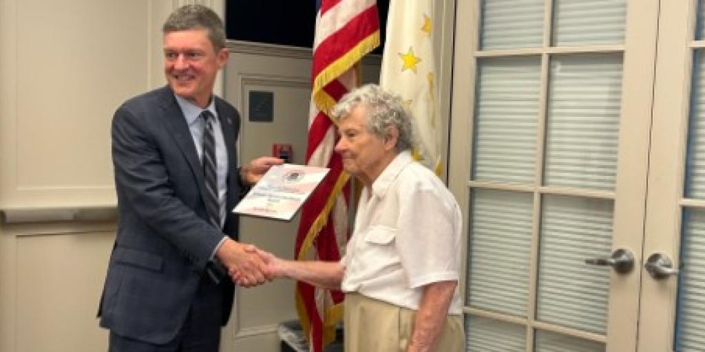 U.S. Air Force Veteran Carolyn Spinney receives her honorary degree from the University of Rhode Island's Bob Flynn.