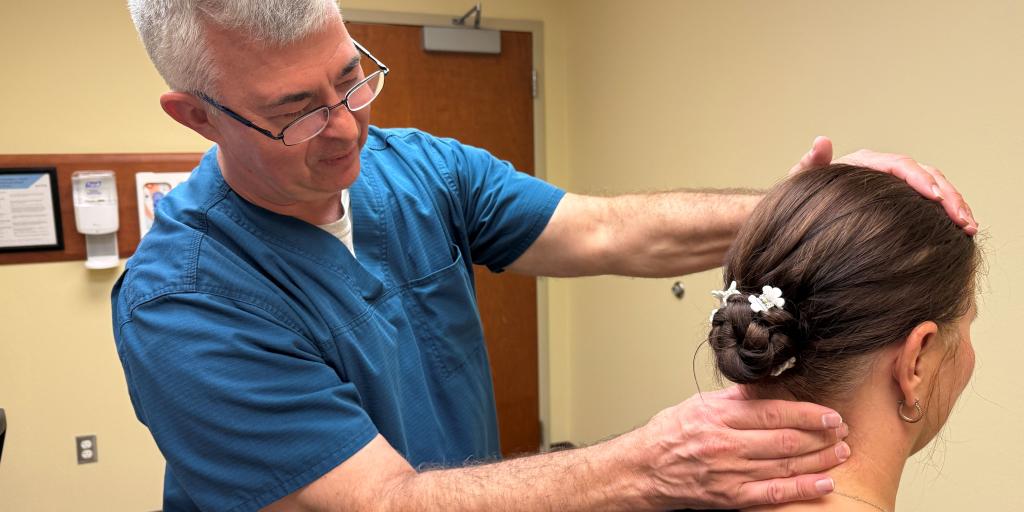 Dr. Paul Bickford performs a preliminary exam of a Veterans neck as part of their chiropractic care at the Abilene VA CBOC.