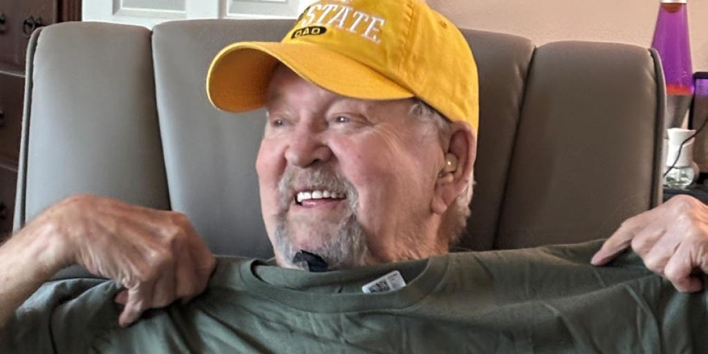 Army Vet holds up tshirt of old unit.