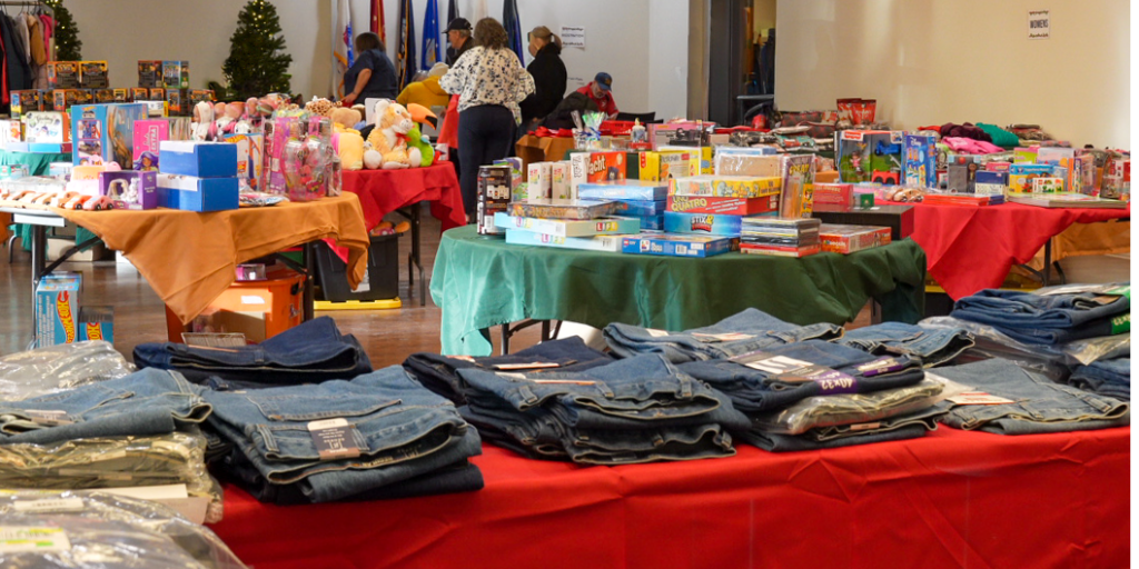 tables with gifts fill the room. Veterans and Volunteers browse through the selection of free gifts.