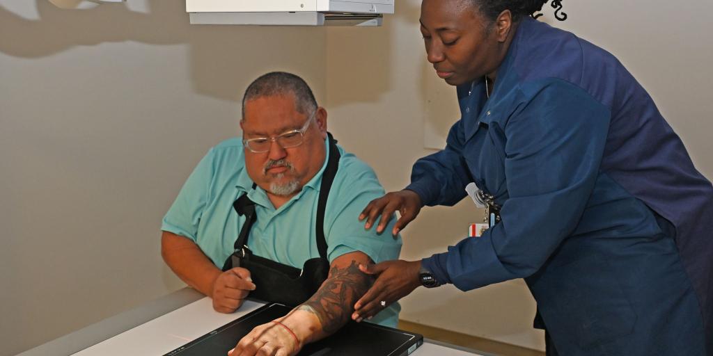 Jacksonville Hospital Corpsman 2nd Class Andrea Thomas positions Veteran Baudelio Alegria's wrist for X-rays 