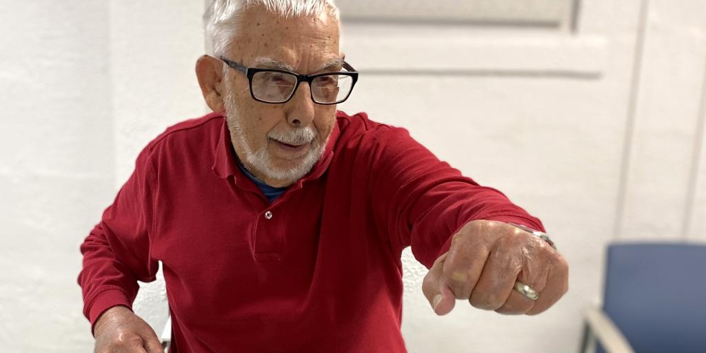 100-year-old Veteran performs a standing Tai Chi move. 