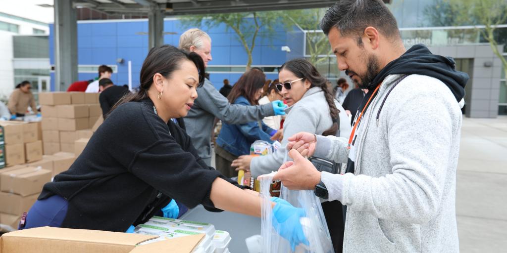 Three Square Staff and VA Staff working together with food donations from local businesses to fill bags for families in Southern Nevada. 