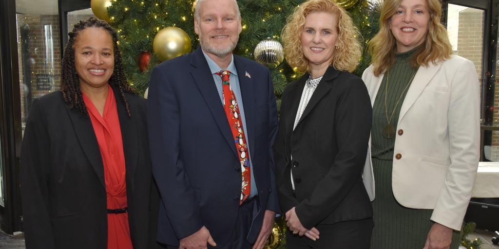 The Dayton VA Medical Center Executive Leadership Team dressed professional and standing in front of a holiday tree.
