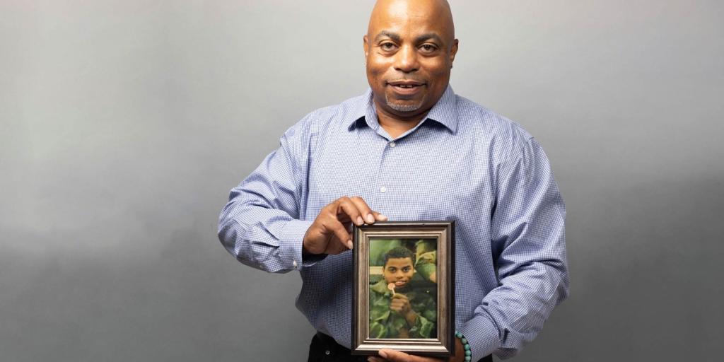 Veteran Charles Bazier displaying a photograph from when he was active duty.