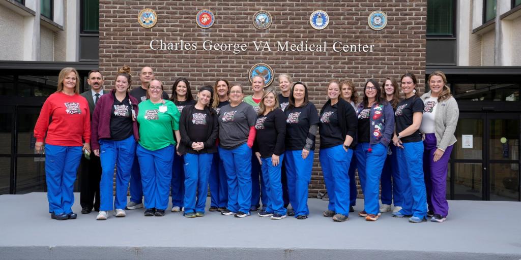Group photo of medical staff in front of a brick building.