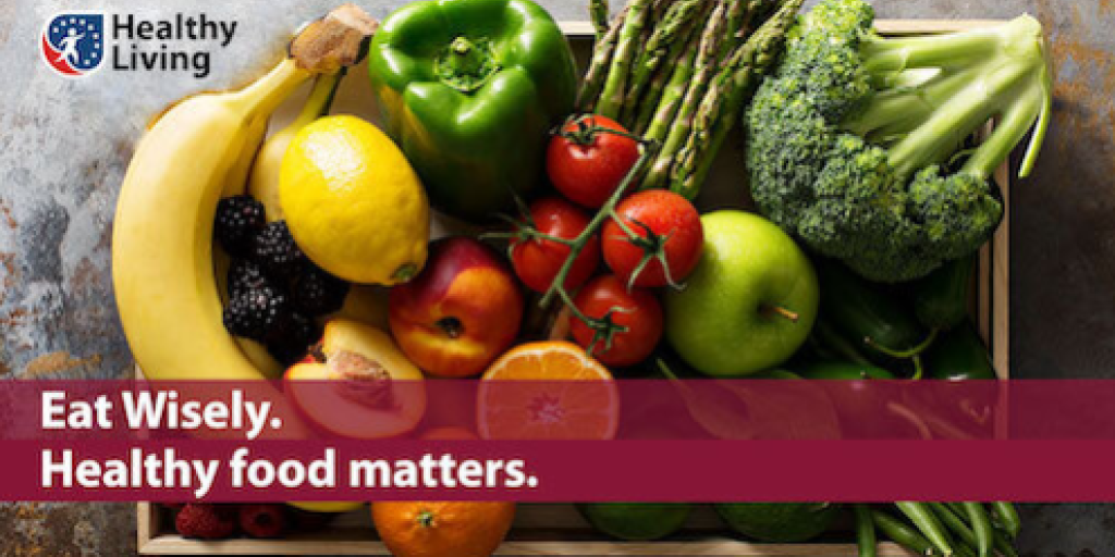 Wooden crate filled with various fruits and vegetables, with text "Eat Wisely. Healthy food matters."