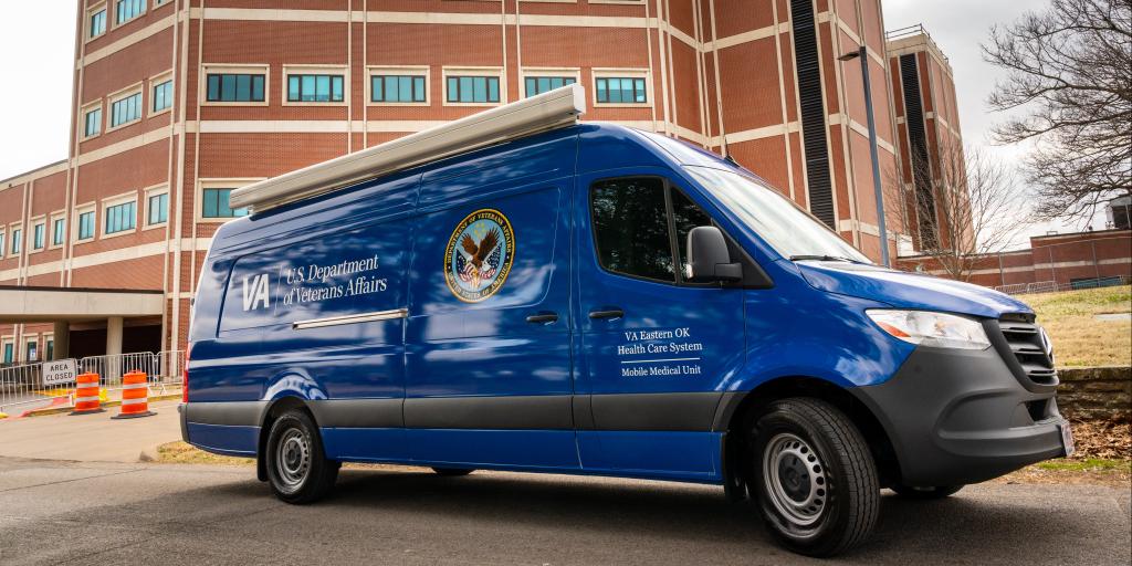 A blue VA mobile medical unit is parked outside Jack C. Montgomery VA Medical Center in Tulsa to support Veterans experiencing homelessness.