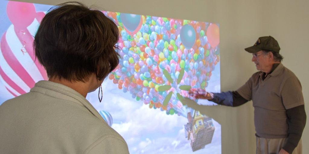 Nurse and Veteran view a large screen showing a colorful hot air balloon.