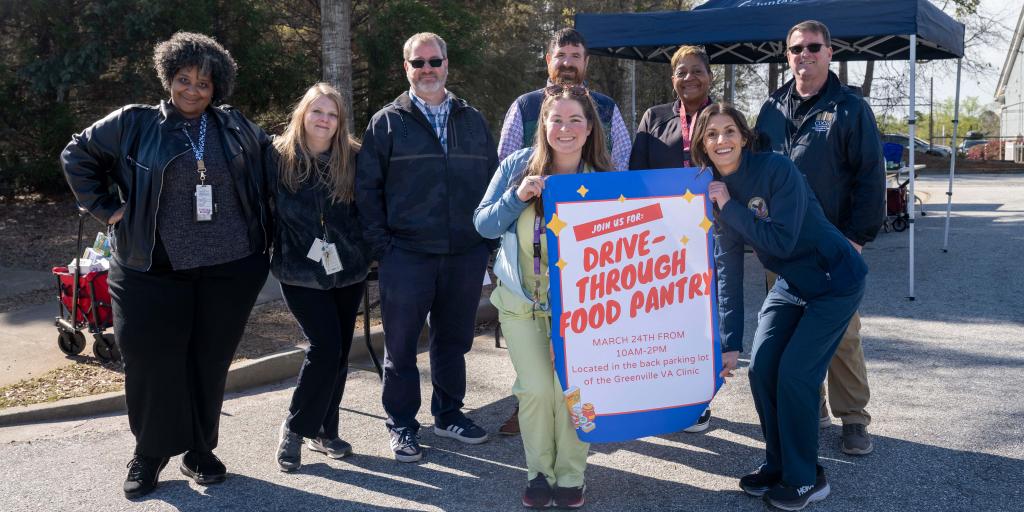 Greenville VA Clinic Employees holding a sign that says "Drive-Through Food Pantry".