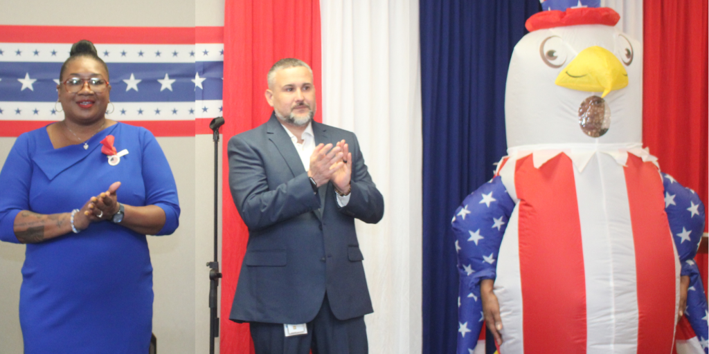 A woman and man in formal wear stand beside an Uncle Sam inflatable.