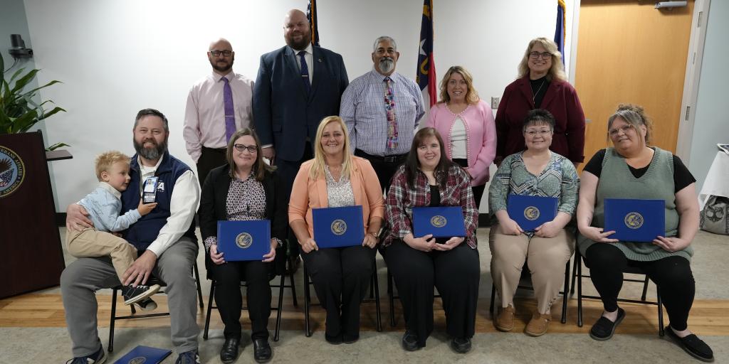 Group photo of people holding certificates and smiling.