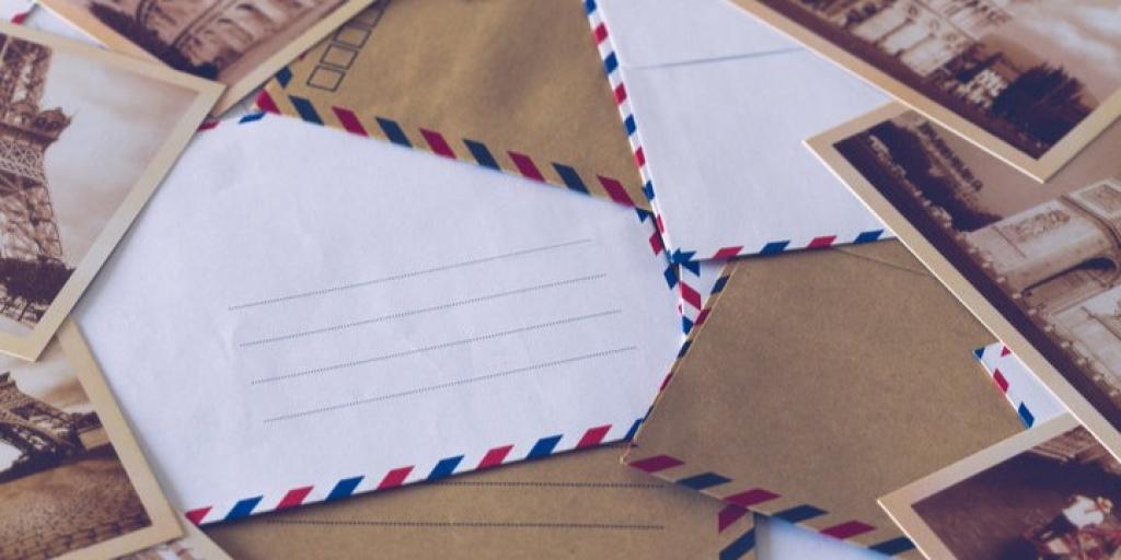 Several vintage postcards and envelopes with red and blue stripes.